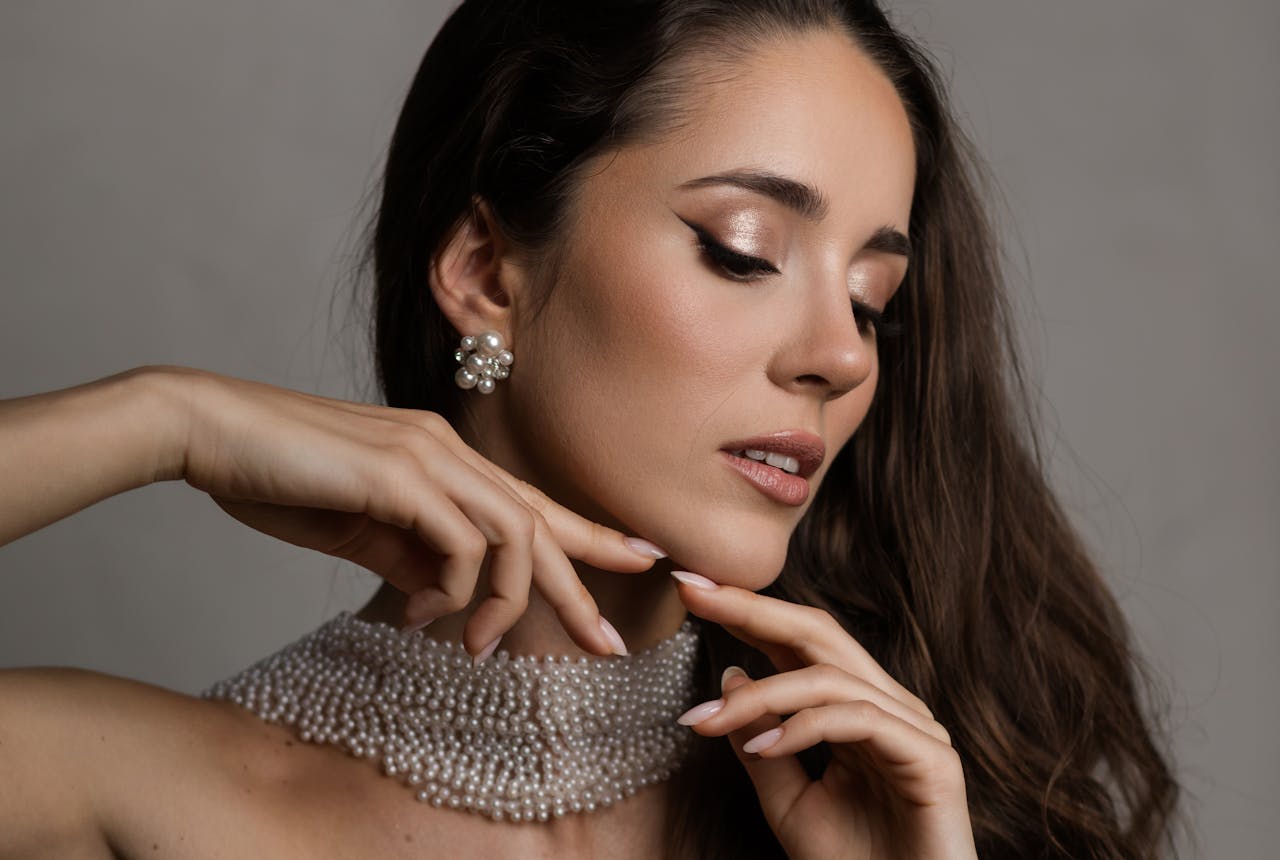 who-we-are Close-up portrait of a stylish woman wearing pearl jewelry and makeup.